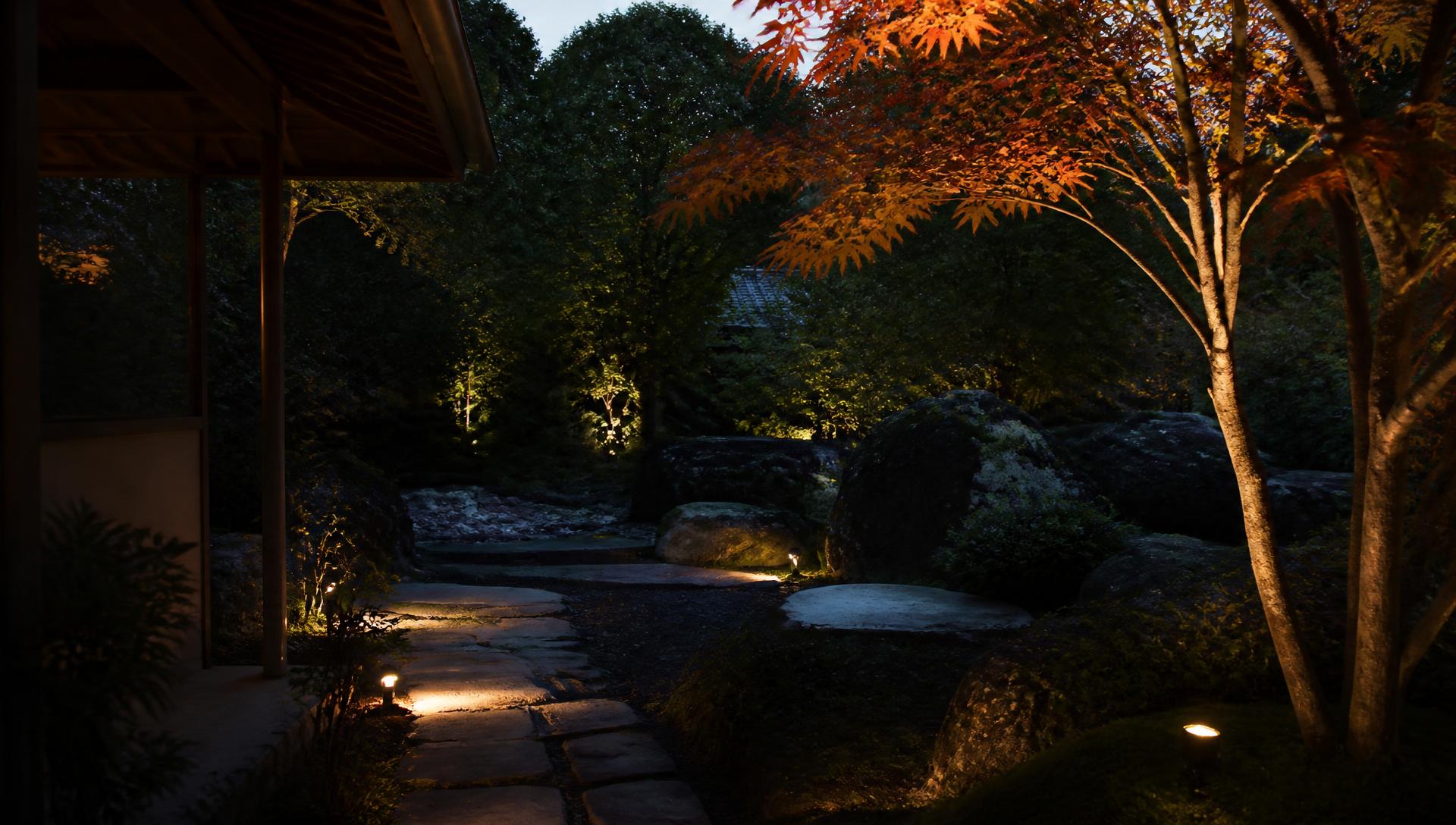 A Japanese-inspired garden at dusk with soft landscape lighting